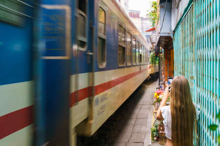 Tourist taking photo of train passing old town in Hanoiのeditorial素材