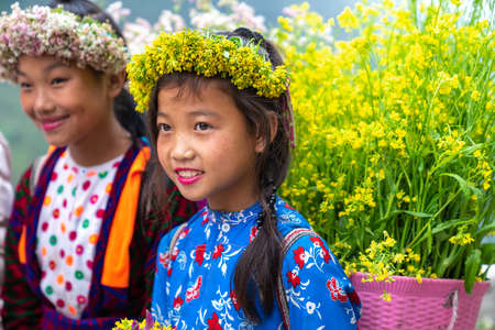 Ha Giang, Vietnam - Nov 24, 2018: Ethnic minority children with flower basket on back in Quan Ba districtのeditorial素材