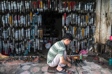 Hanoi, Vietnam - July 10, 2018: Many old shock absorbers hanging at a repair shop on Hanoi street, Vietnamのeditorial素材