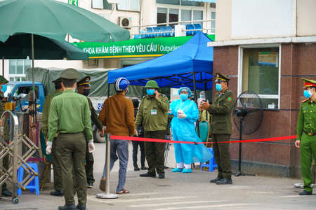 Hanoi, Vietnam - Mar 31, 2020: Control activities at main entrance of Bach Mai hospital, locked down as a major Covid-19 outbreak area, during covid-19 coronavirus pandemicのeditorial素材