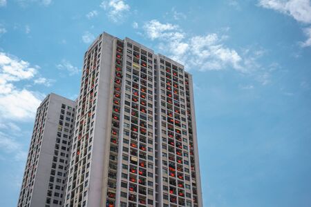 Modern apartment building with a lot of Vietnamese flags hanging on windows during importance...