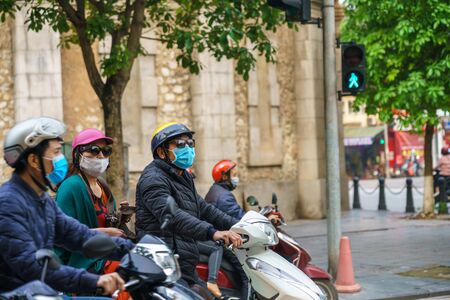 Side view of a people on a motorcycle scooter stop at crosswalk in Hanoi city, Vietnam