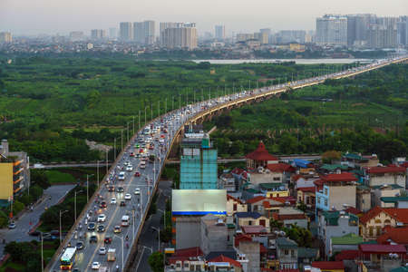 Cityscape of Hanoi skyline at Vinh Tuy bridge over Red river during sunset time