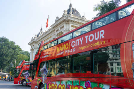 Hanoi, Vietnam - Feb 18, 2019: Luxury city tour bus on Hanoi street with Hanoi Opera House on backgroundのeditorial素材