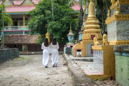 Vietnamese women in traditional dress Ao Dai walking in an ancient Buddhist temple in Southern Vietnamの写真素材