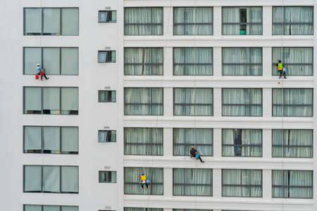 Asian industrial worker cleaning windows of a modern building.の写真素材