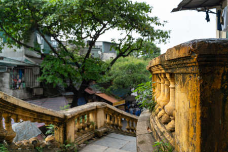Old open outer stone staircase, steps of the old staircase with traces of weathering and destruction. Aged footpath in Hanoi cityの写真素材