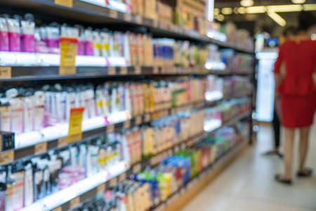 Abstract blurred supermarket aisle with colorful shelves and unrecognizable customers as backgroundの写真素材