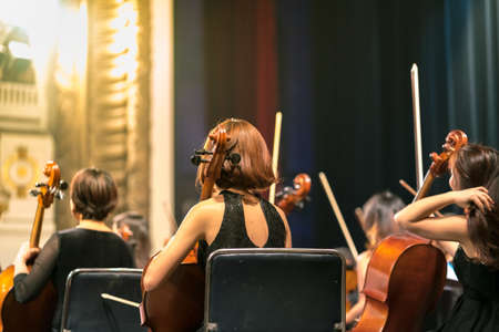 Musician play violin. Female violinist playing the violin stringst on the concert stage. Closeup.の写真素材