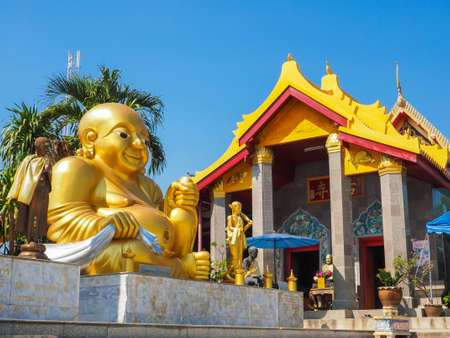 KATYAYANA BUDDHA IN TEMPLE WITH GOLDEN ROOF BACKROUD AND BLUE SKYの写真素材