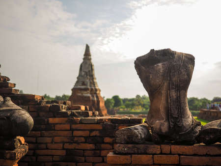 Broken buddha statue with pagoda backgroundの写真素材