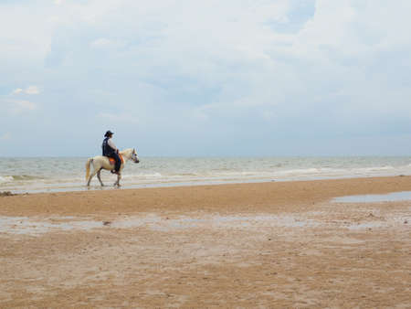 MAN RIDING A HORSE ON THE BEACHの写真素材