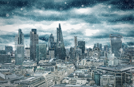 The skyline of the City of London with a snow blizzard in winter, United Kingdomの写真素材