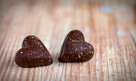 Closeup of two chocolate hearts on wooden background for valentines dayの写真素材