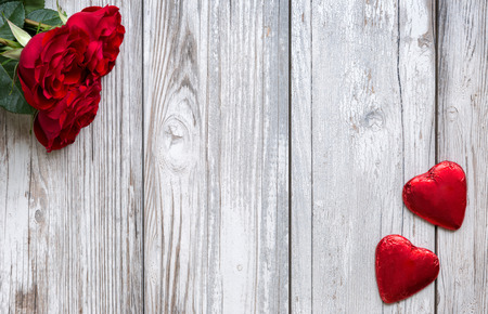 Red roses and hearts on white, wooden background for Valentines Dayの写真素材