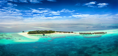 Aerial view of a tropical island with turquoise waters and white sand beaches in the Maldivesのeditorial素材