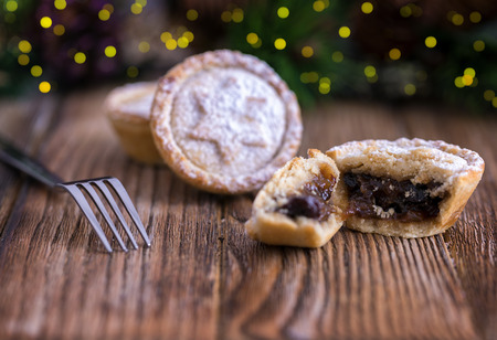 Cracked mince pie on a rustic surfaceの写真素材