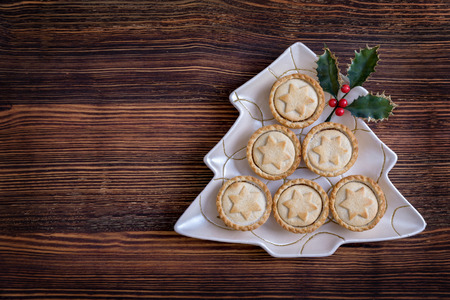 Traditional british mince pies on a christmas tree shaped plate for christmasの写真素材