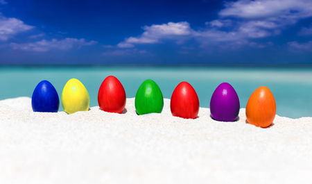 Colorful easter eggs in a row on a tropical beach in the Maldivesの写真素材