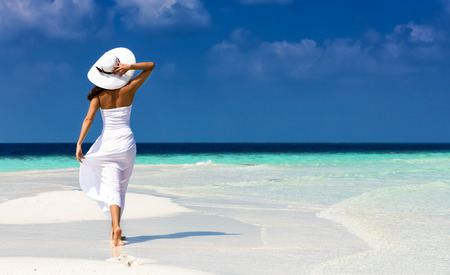 Girl in white on a sandbank in the Maldivesの写真素材