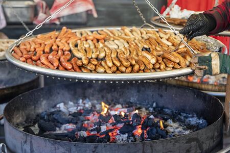 A pile of traditional, fresh German sausages over a charcoal grill on a christmas market in Germanyの写真素材