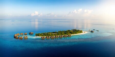 Panoramic aerial view to a tropical paradise island in the Maldives, Indian Ocean, during sunset timeの写真素材