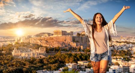 Greece traveling concept: a happy tourist woman with outstretched arms stands in front of the Acropolis of Athensの写真素材