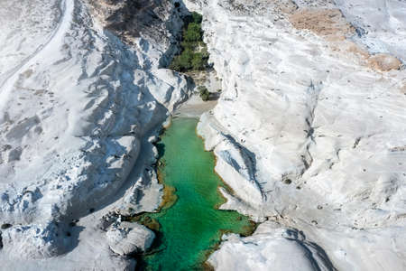 The beautiful Sarakiniko Beach with emerald shining water between the white, volcanic rocks of Milos island, Cyclades, Greeceの写真素材
