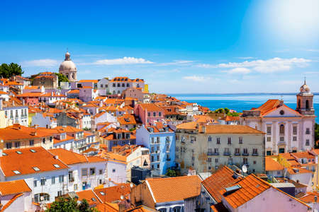 The beautiful skyline of Lisbon, Portugal, with red roofed, colorful houses in the Alfama district...
