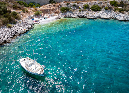 A picturesque, small beach with a traditional fishing boat at the coastal road of Athens to Sounio, Attica, Greeceの写真素材