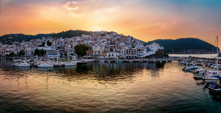 Panoramic view of the city and harbour of Skopelos island, Sporades, Greece, during a golden summer sunsetの写真素材