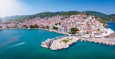 Panoramic aerial view of the beautiful town and harbour of Skopelos island with the traditiona, red...