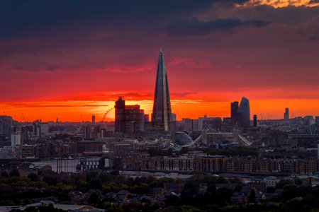 Elevated view of the London skyline during a cloudy sunset with intense red colors and sunlight during autmn time, Englandの写真素材