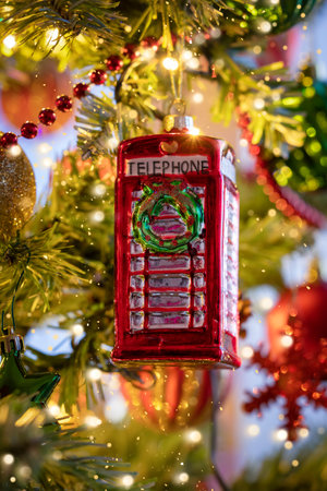 A classic, british, red telephone booth from England as a christmas ornament on a illuminated tree with selective focusの写真素材