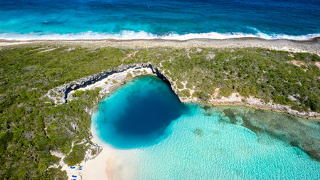 Aerial top view of the famous Deans blue hole with the connecting turquoise lagoon next to the blue ocean, Long Island, Bahamasの写真素材