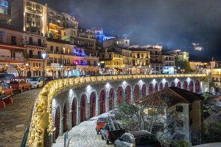 The village of Arachova, Greece, next to the mountain Paranssus during a cold winter night with Christmas decoration lightsの写真素材