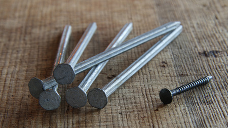 A group of similar nails and a different lonely nail outsideの写真素材