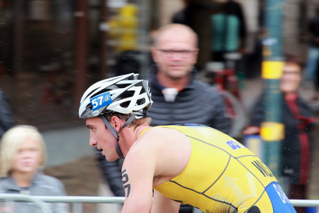 STOCKHOLM - AUG 23, 2014: Dan Wilson (AUS) cycling in the rain during the Men's ITU World Triathlon series event Aug 23, 2014 in Stockholm, Swedenのeditorial素材