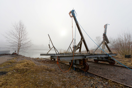 Vehicle on rail road used to launch boats to the sea in the harbor a foggy morningの写真素材