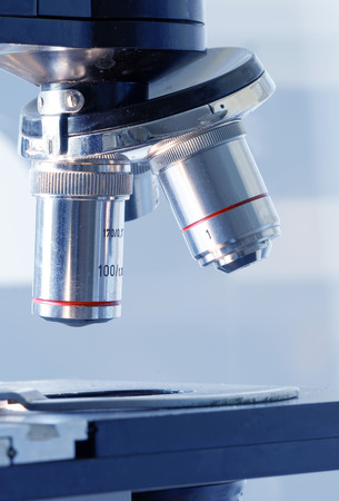 Close up of microscope lenses with blue tint, soft focus on bright backgroundの写真素材