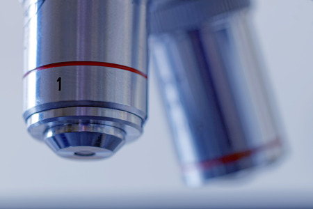 Close up of two microscope lenses with soft focus, blue tint and bright backgroundの写真素材