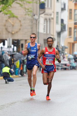 STOCKHOLM - MAY 30, 2015: Dadafo Dhaqabi Tesama (NOR) and Kaupo Sasmin (EST) struggeling in the rain after 15 km in the ASICS Stockholm Marathon event May 30, 2015 in Stockholm, Swedenのeditorial素材