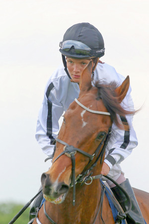 STOCKHOLM - JUNE 06: Concentrated female jockey on her race horse at the Nationaldags Galoppen at Gardet. June 6, 2015 in Stockholmのeditorial素材