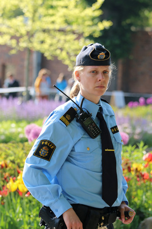 STOCKHOLM - JUN 06, 2015: Swedish police woman prepared to protecting the royal family on their way to celebrate the swedish national dayのeditorial素材