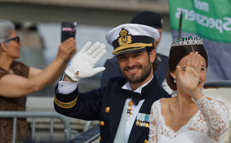 STOCKHOLM - JUN 13, 2015: The swedish Prince Carl-Philip Bernadotte and his wife Princess Sofia Hellqvist a few minutes after the royal wedding smiling and waiving to the audienceのeditorial素材