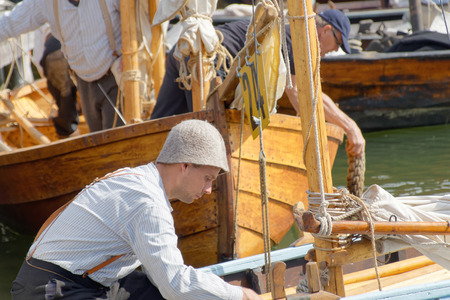GRISSLEHAMN - JUN 13, 2015: Sailors in vintage clothes preparing old sailing ships in the public event Postrodden, June 13, 2015 in Grisslehamn, Swedenのeditorial素材