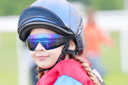 STOCKHOLM - JUNE 06: Young girl wearing sun glasses sitting on a pony at the Nationaldags Galoppen at Gardet. June 6, 2015 in Stockholmのeditorial素材