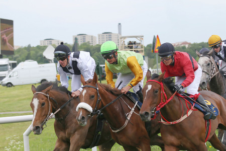 STOCKHOLM - JUNE 06: Tough race between three race horses and the standing jockeys  at the Nationaldags Galoppen at Gardet. June 6, 2015 in Stockholmのeditorial素材