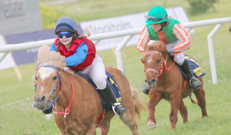 STOCKHOLM - JUNE 06: Tough race between two pony race horses at the Nationaldags Galoppen at Gardet. June 6, 2015 in Stockholmのeditorial素材