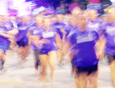 STOCKHOLM, SWEDEN - AUG 15, 2015: Large group of runners in blue dresses with motion blur in the running event Midnattsloppet, August 15, 2015 in Stockholm, Swedenのeditorial素材